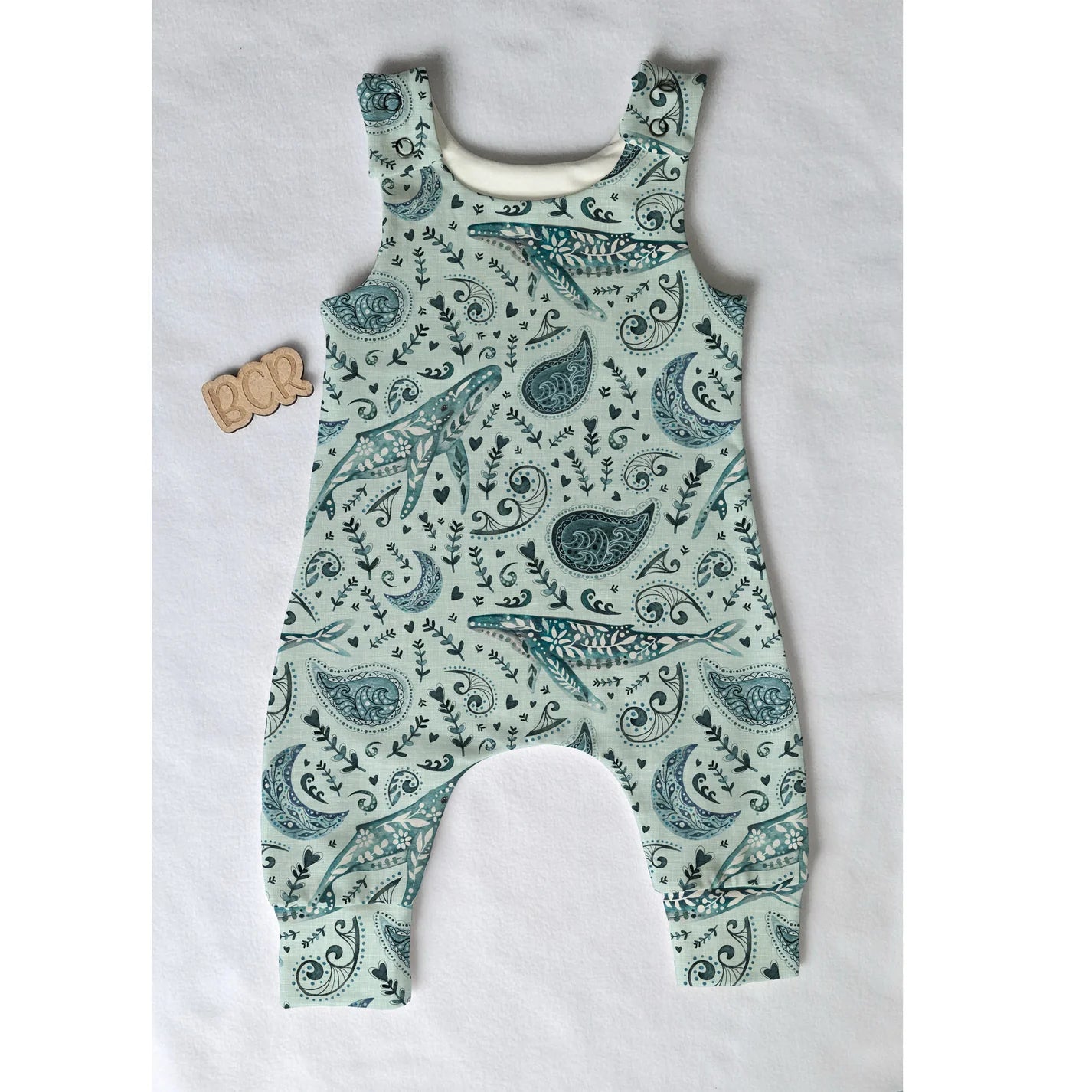 organic baby romper flat lay featuring scandi whales design
